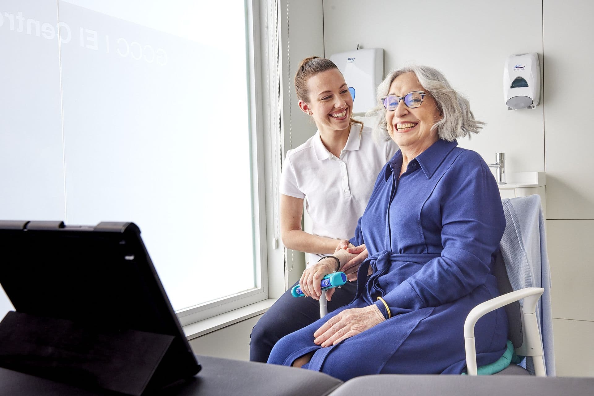 Resident and therapist laughing during a wellness screening session